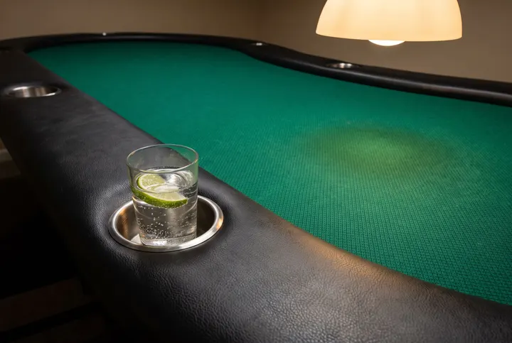 Poker table rail with a glass of sparkling water
